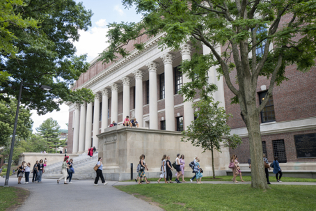 A group of visitors walk past the Harry Elkins Widener Memorial Library, Harvard University's flagship library, in Cambridge, Massachusetts.