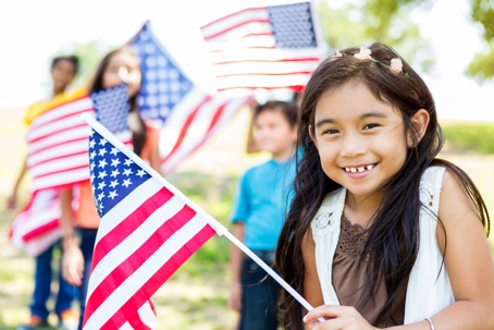 young child waving American flag